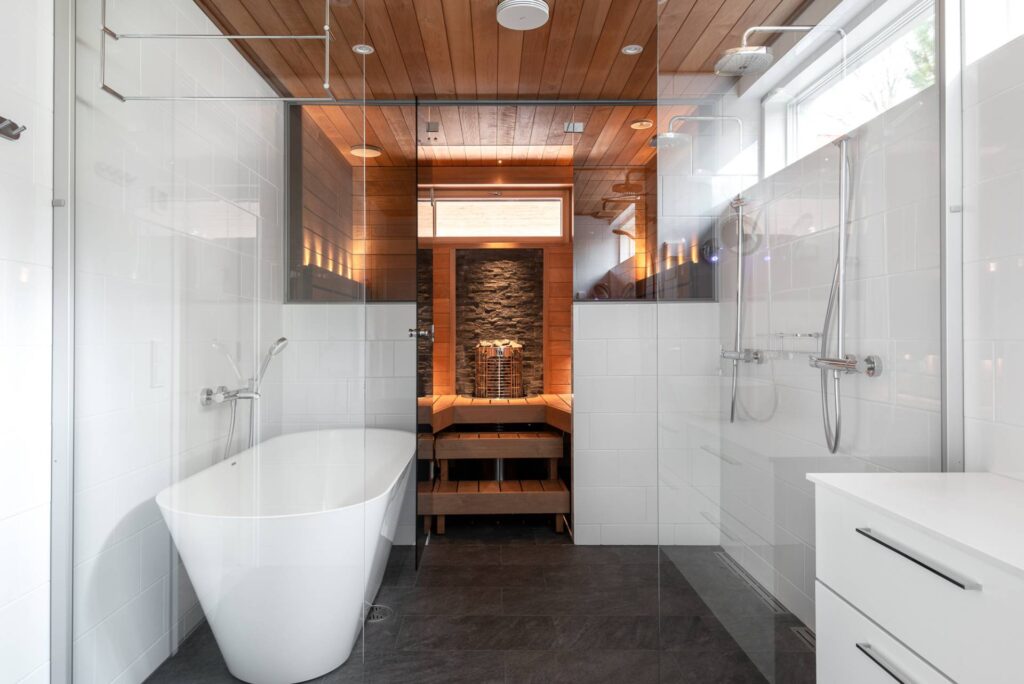 Mondex saunan suunnittelu ja saunaremontti artikkelin kansikuva, jossa vaalea kylpyhuone ja sauna Mondex-Kalla -kiukaalla.