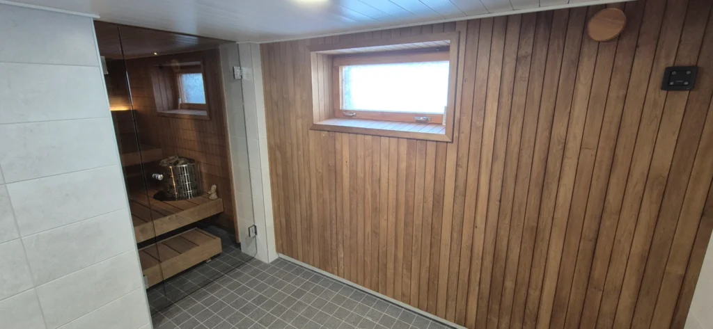 Mondex Teno ja sauna ja kylpyhuone, joissa molemmissa käytetty puupanelointia.